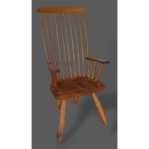 440 - An elm Windsor armchair with a shaped spindle back above a panel seat raised upon turned legs