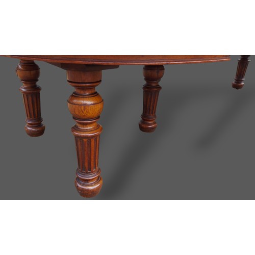 393 - A 19th Century Pollard oak dining table by Gillow and Co. the moulded top above a plain frieze raise... 