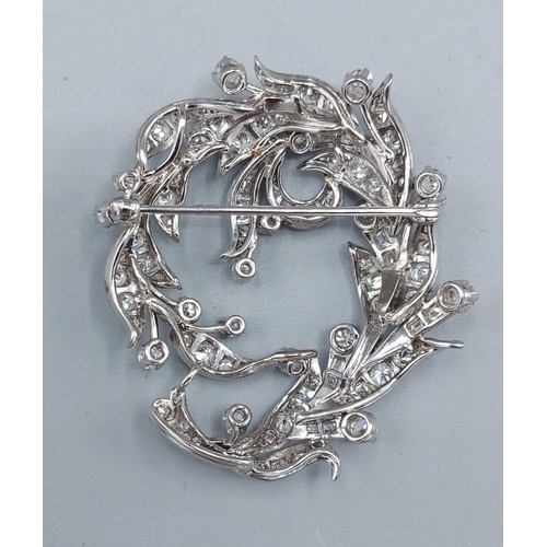 140 - A white gold Diamond set brooch of pierced scroll form, 4cms by 5cms, 20gms