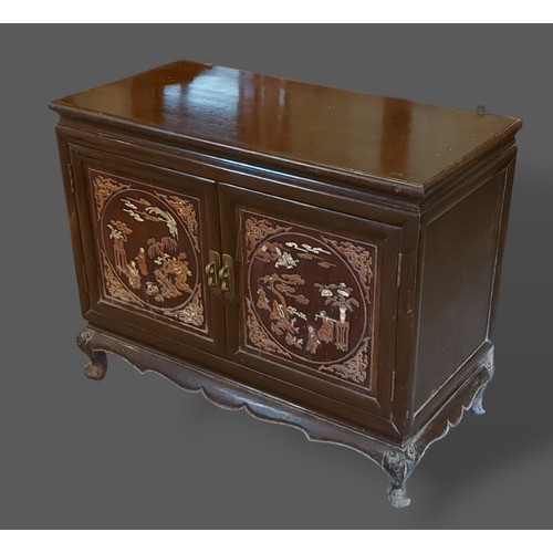 399 - A Chinese hardwood low side cabinet with two lacquered doors enclosing drawers upon low feet, 90cms ... 