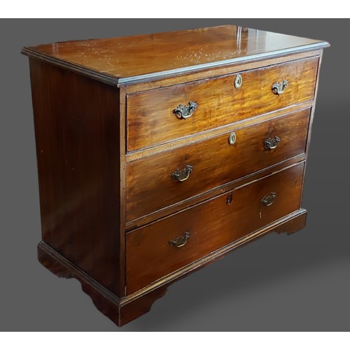 414 - A 19th Century mahogany chest, the moulded top above three drawers with brass handles and escutcheon... 