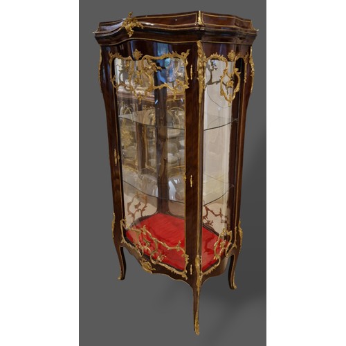 468 - A French large Vitrine with a serpentine glazed double sided door enclosing glass shelves raised upo... 