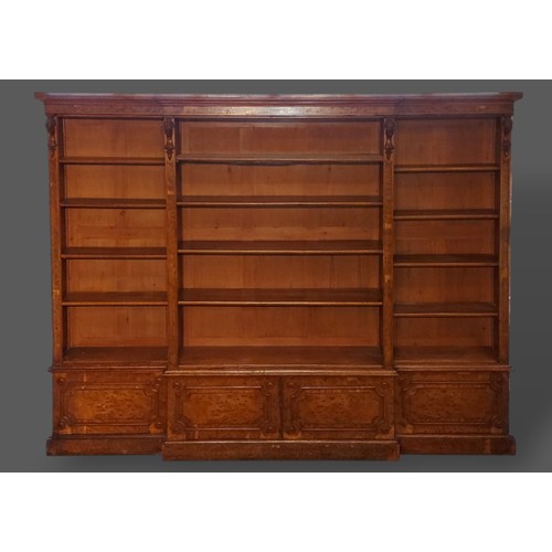 219 - A 19th Century burr oak breakfront bookcase, the moulded cornice above open shelves with four doors ... 