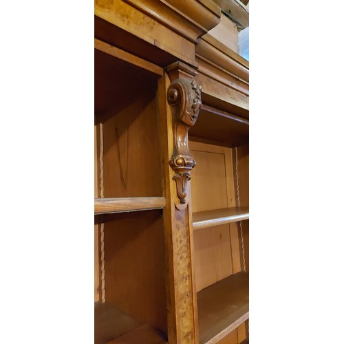 219 - A 19th Century burr oak breakfront bookcase, the moulded cornice above open shelves with four doors ... 