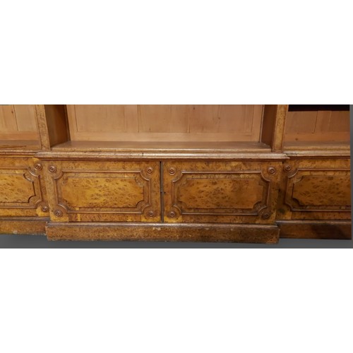 219 - A 19th Century burr oak breakfront bookcase, the moulded cornice above open shelves with four doors ... 