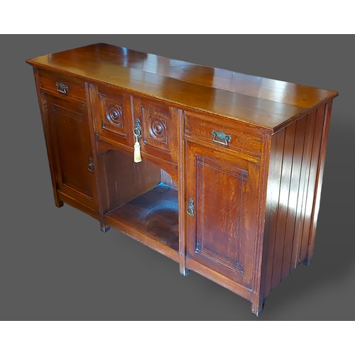 228 - An Arts and Crafts oak sideboard by H. Ogden, Manchester, with two drawers, four cupboard doors and ... 