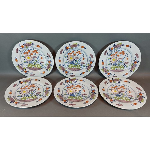 15 - A set of six delft plates hand painted with flowers in coloured enamels, 26cms diameter