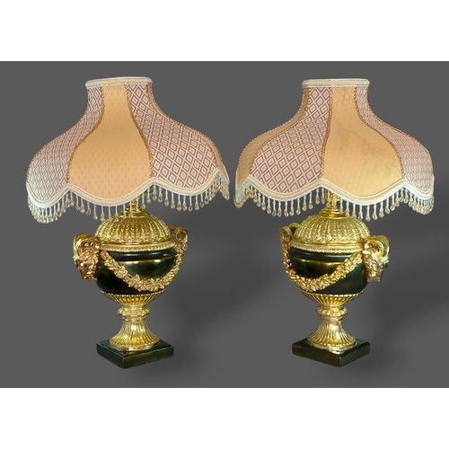 186 - A pair of French style simulated bronze lamps with Rams head surmounts, 47cms tall excluding shades