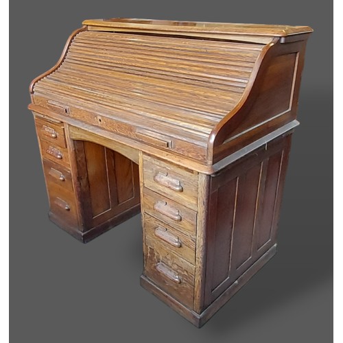 272 - A Circa 1930's oak roll top desk with a shaped tambor above various pedestal drawers, 121cms wide, 7... 