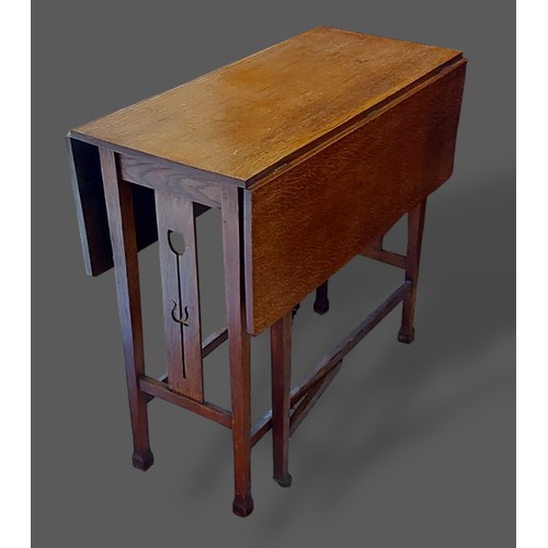 275 - An Arts and Crafts oak gate leg table with Tulip carved pierced end supports, 76cms wide