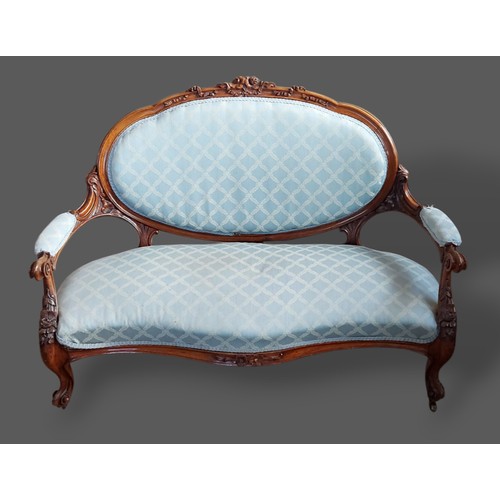 220 - A Victorian mahogany settee, the carved oval and upholstered back above a stuffover seat raised upon... 