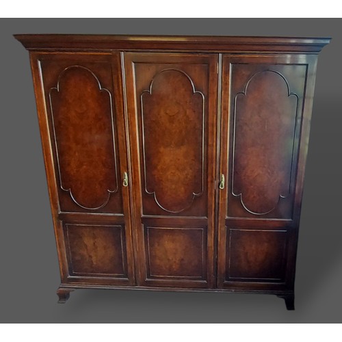 224 - A Circa 1920's Queen Anne style walnut wardrobe, the moulded cornice above three moulded doors with ... 