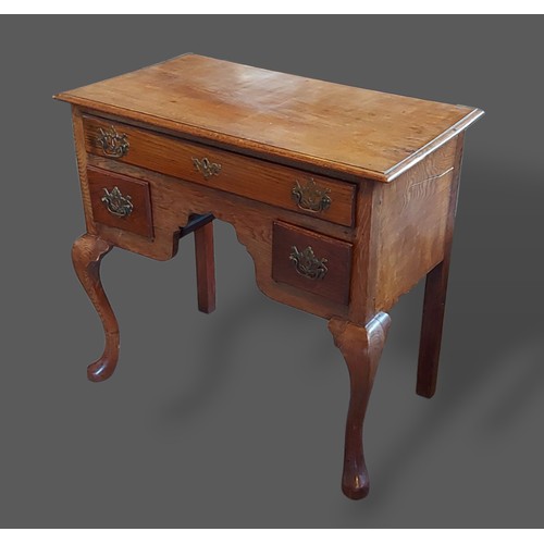 241 - A 19th Century oak lowboy, the moulded top above three drawers with brass handles raised upon cabrio... 
