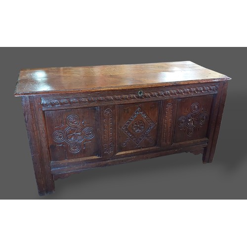 244 - An 18th Century oak Coffer, the hinged top above a triple carved panel front flanked by stiles, 141c... 