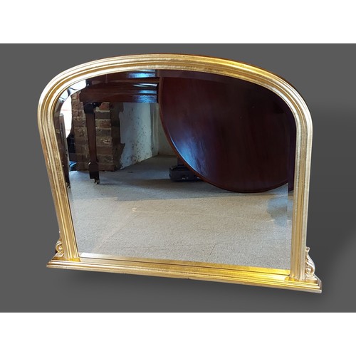 247 - A gilt framed overmantle mirror of arched form, 80cms x 105cms