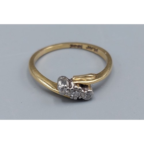 104 - An 18ct gold three stone Diamond ring of crossover form, 2.5gms, ring size K