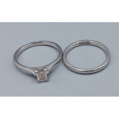 117 - A Platinum solitaire Diamond ring set with an Emerld cut Diamond, claw set, together with a Platinum... 