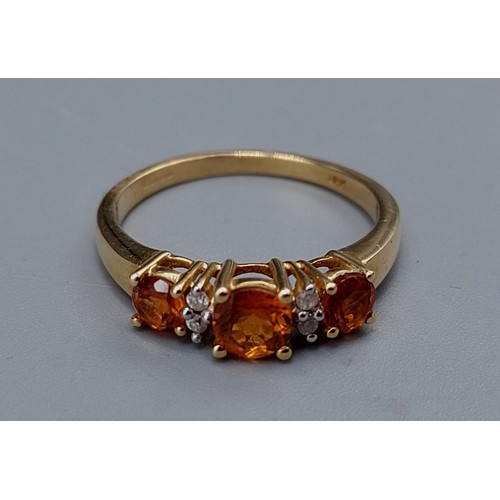 121 - An 18ct gold ring set with three orange stones and four Diamonds, ring size P, 4gms