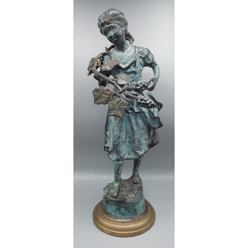 202 - A patinated bronze model of a girl with fruit, 48cms tall