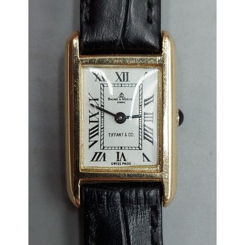 74 - A 14ct gold cased ladies wristwatch by Baume and Mercier retailed by Tiffany and Co. with leather st... 