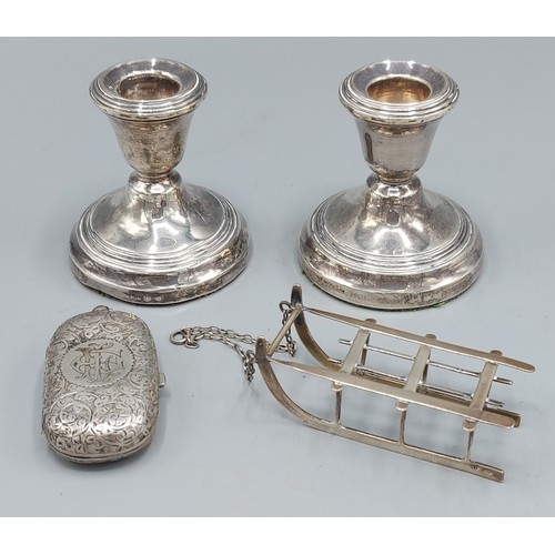 107 - A pair of Birmingham silver dwarf candlesticks together with an 800 mark silver model of a toboggan ... 
