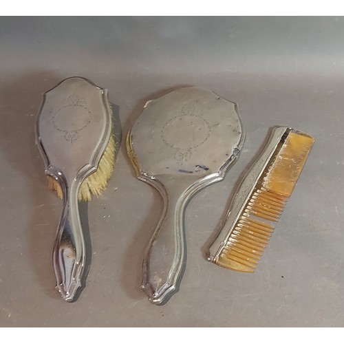 110 - A Birmingham silver backed three piece dressing table set comprising hand brush, mirror and comb