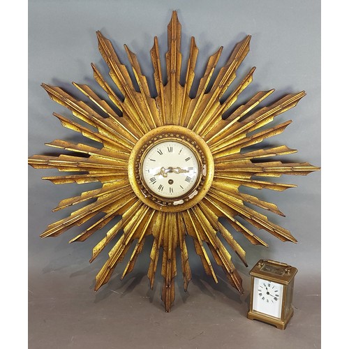 327 - A gilded Sunburst wall clock, 64cms diameter together with a French brass cased Carriage clock
