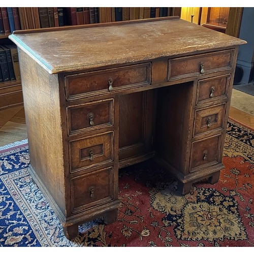 346 - An oak kneehole desk, the moulded top above eight moulded drawers with brass drop handles raised upo... 