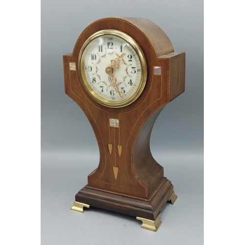 332 - An Edwardian mahogany and inlaid mantle clock of shaped form, the enamel dial with Arabic numerals a... 