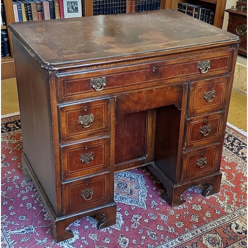 359 - A walnut line inlaid kneehole desk, the crossbanded top with pinched corners above nine drawers and ... 