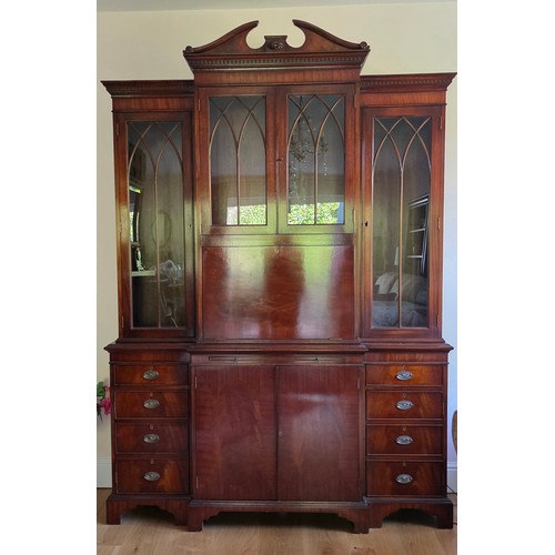 357 - A 20th Century mahogany breakfront bookcase with a moulded cornice above glazed and panel doors rais... 