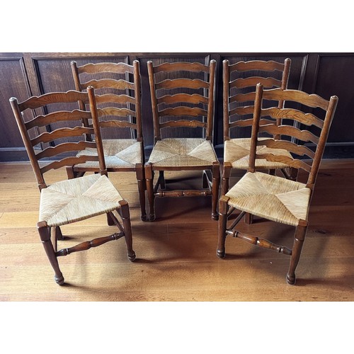 369 - A set of five ladderback dining chairs, each with a rush seat raised upon turned legs with stretcher... 