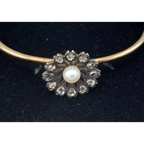 177 - A gold bangle set with a central Pearl surrounded by Diamonds of flower head form, 9.9gms