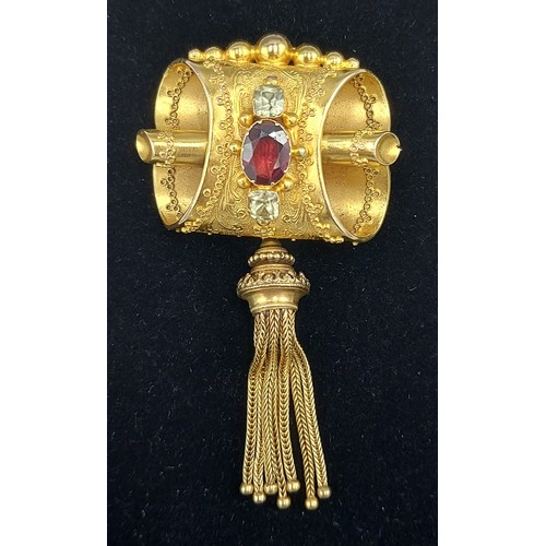 179 - A Victorian tested high grade gold brooch of scroll shaped form withe a central Garnet flanked by cl... 
