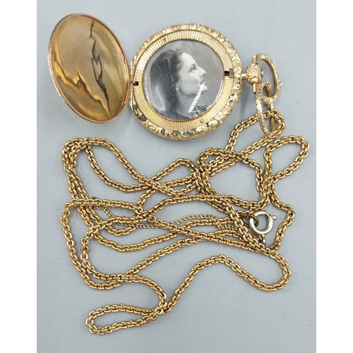 182 - A gold plated locket together with a long guard chain