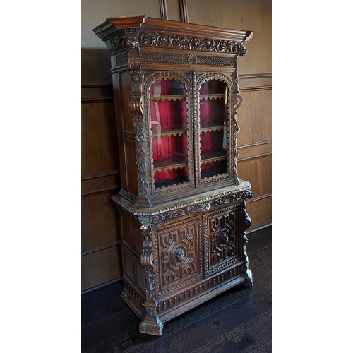 378 - A Victorian carved oak bookcase with a moulded cornice above two glazed doors, the lower section wit... 