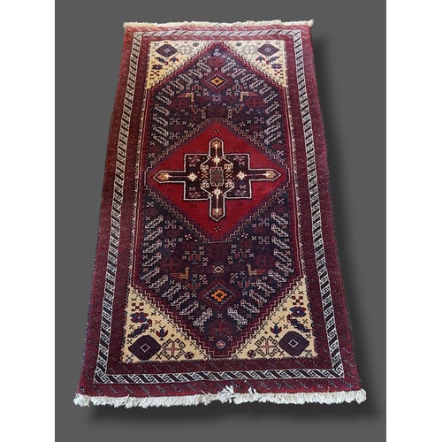 323 - A Northwest Persian woollen rug with a central medallion within an all-over design within multiple b... 