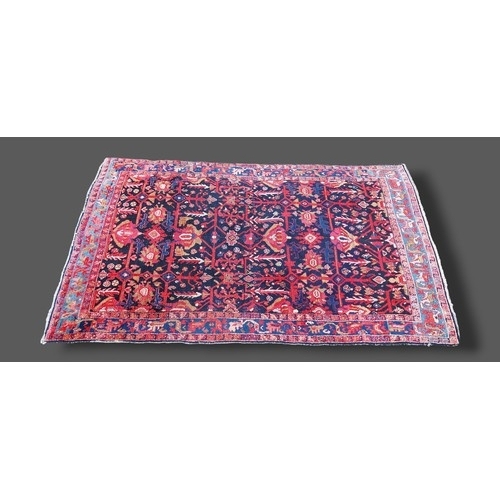 324 - A Northwest Persian style woollen rug with an all-over design upon a red, cream and blue ground with... 