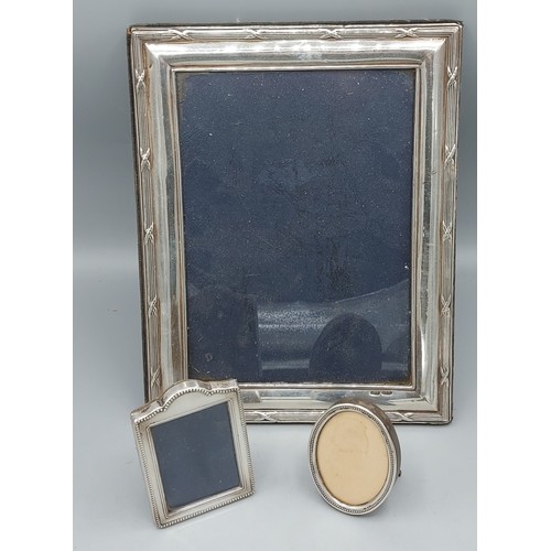 133 - A London silver rectangular photgraph frame, 25cms x 19.5cms together with a 925 silver miniature ph... 