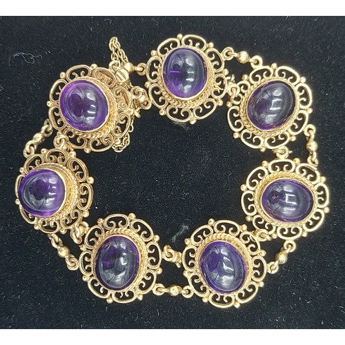 141 - A 9ct gold linked bracelet set with seven cabochon Amethysts within pierced surrounds, 28.1g