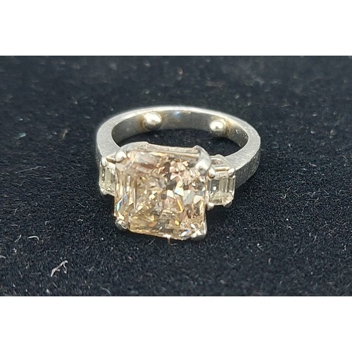 155 - A Solitaire Diamond ring set with  Princess cut Diamond, approx. 5.20ct flanked by Baguette cut Diam... 