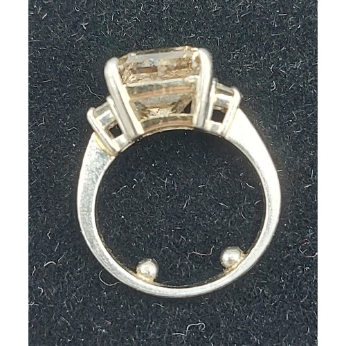 155 - A Solitaire Diamond ring set with  Princess cut Diamond, approx. 5.20ct flanked by Baguette cut Diam... 