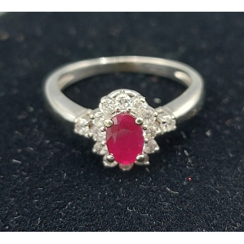 158 - A 14ct gold ring set with a central oval Ruby surrounded by Diamonds with Diamond shoulders, 2.9gms,... 