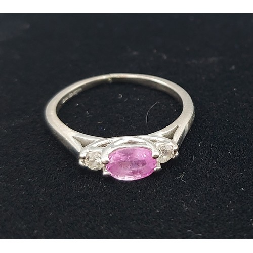 165 - An 18ct white gold ring set with a pink Sapphire flanked by Diamonds, claw set, 2.6gms, ring size K