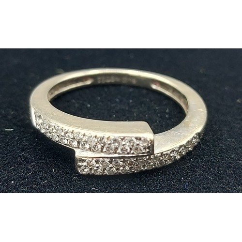 169 - An 18ct white gold crossover Diamond band ring, 3.3gms, ring size M