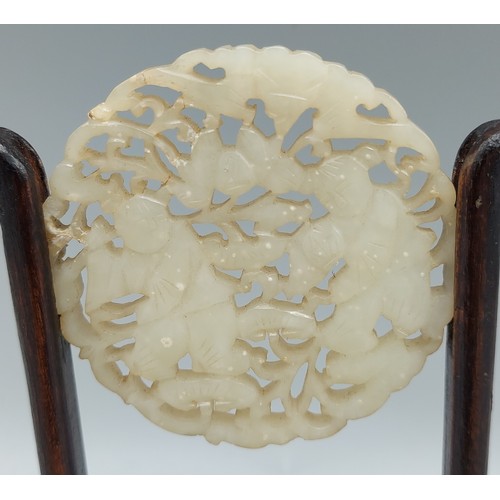 A Chinese Jade panel of circular pierced form with hardwood stand, 6cms ...