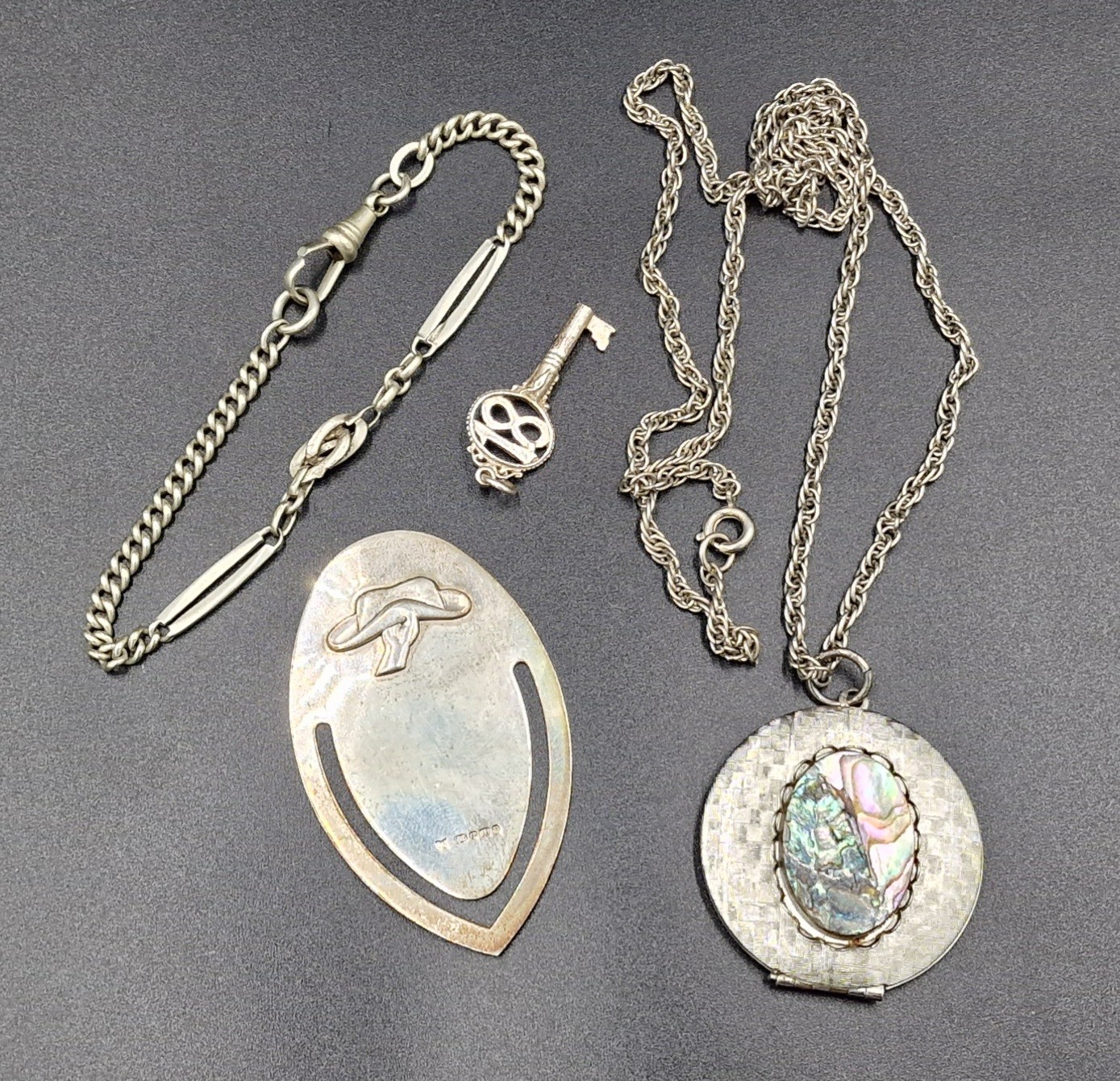 A 925 silver bookmark together with a locket with chain, a watch chain ...