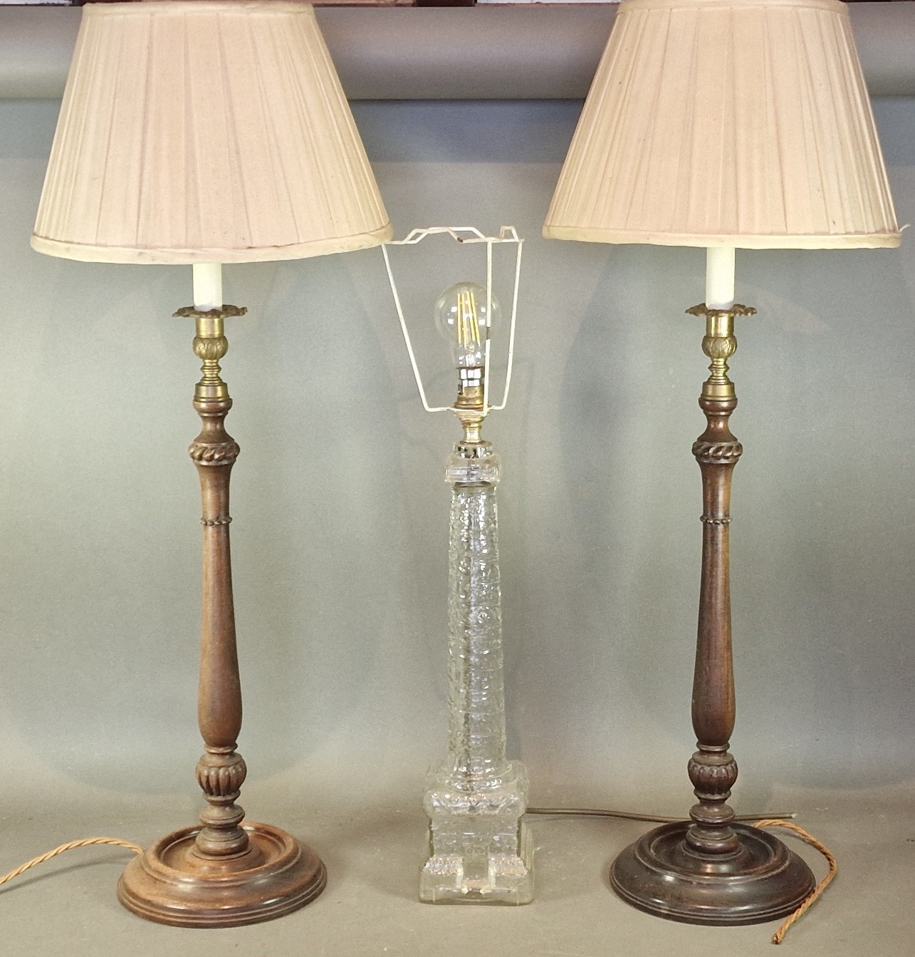 A pair of mahogany table lamps together with a glass table lamp