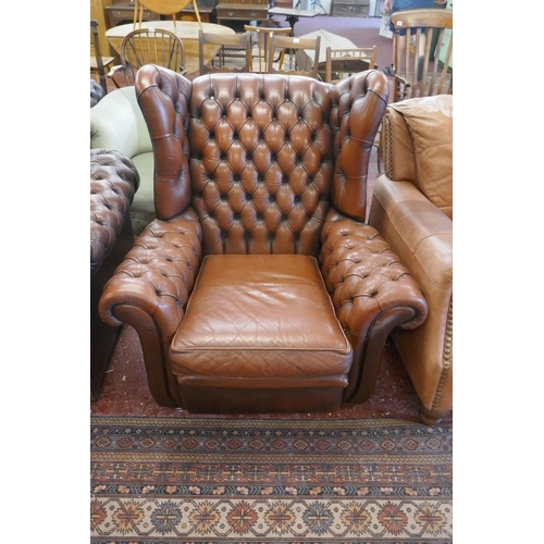 369 - Brown leather button back wing-back armchair