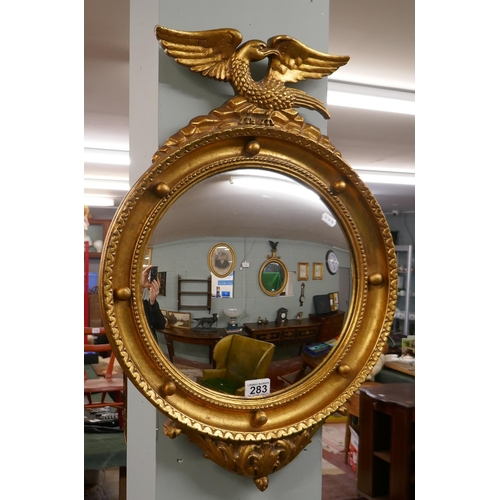 283 - Gilt framed convex mirror adorned with eagle